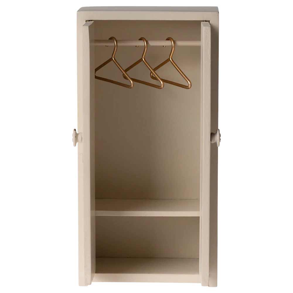 Maileg - Miniatur-Kleiderschrank Maus in Beige verfügt über eine offene Tür, drei goldene Kleiderbügel an einer Stange und zwei Regale unten.
