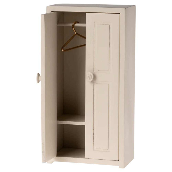 Ein kompakter, cremefarbener Miniatur-Kleiderschrank für Mäuse von Maileg mit leicht geöffneter Tür, einem Kleiderbügel aus Metall und zwei Innenregalen.