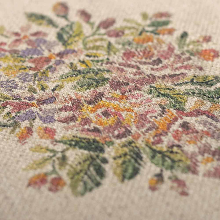 Nahaufnahme des Maileg-Miniatur-Teppichs Blumen, der sein florales Kreuzstichmuster mit rosa, violetten und gelben Blumen, ergänzt durch grüne Blätter, zeigt.