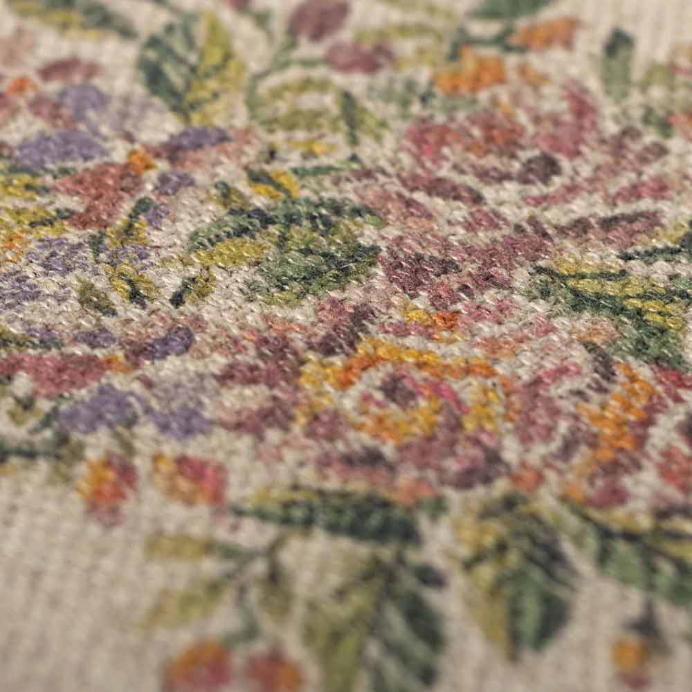 Nahaufnahme des Maileg Miniatur Teppich Blumen, der aufwendig gewebte Blumen in Grün-, Gelb-, Orange- und Lilatönen auf strukturiertem Stoff zeigt.