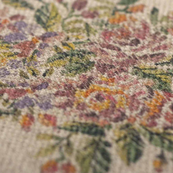 Nahaufnahme des Maileg Miniatur Teppich Blumen, der aufwendig gewebte Blumen in Grün-, Gelb-, Orange- und Lilatönen auf strukturiertem Stoff zeigt.