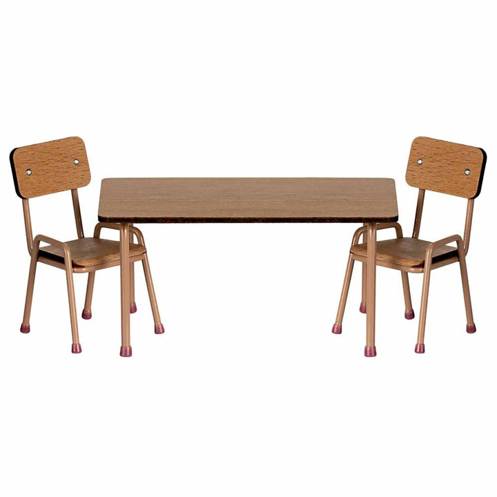 Das Maileg Puppenmöbel-Set besteht aus einem kleinen Holztisch und zwei dazu passenden Stühlen mit hellbraunen Sitz- und Rückenlehnen sowie rosa Spitzen an den Beinen.