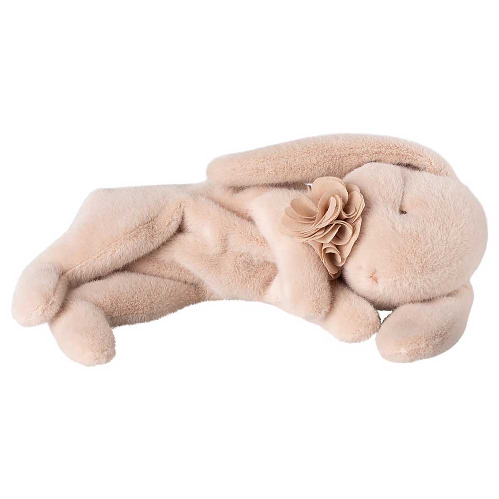 Der Maileg - Schlafender Plüsch Hase, ein beiger Plüschhase mit langen Ohren, liegt auf der Seite und hat eine dekorative Stoffblume auf der Brust.