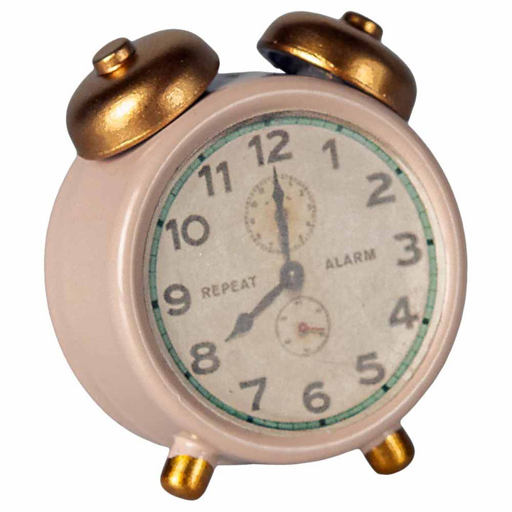 Der „Maileg - Wecker Miniatur für Maus“ ist ein kleiner Wecker im Vintage-Stil mit beigem Gehäuse, zwei Glocken oben und goldenen Akzenten. Auf dem Zifferblatt sind die Zahlen 1 bis 12 sowie zusätzliche kleinere Zifferblätter zu sehen.
