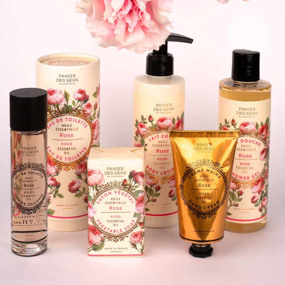 Ein Display von Panier des Sens – Feste Pflanzenseife Rose 150 g, inklusive Körperlotion, Duschgel und Handcreme, mit floraler Verpackung.