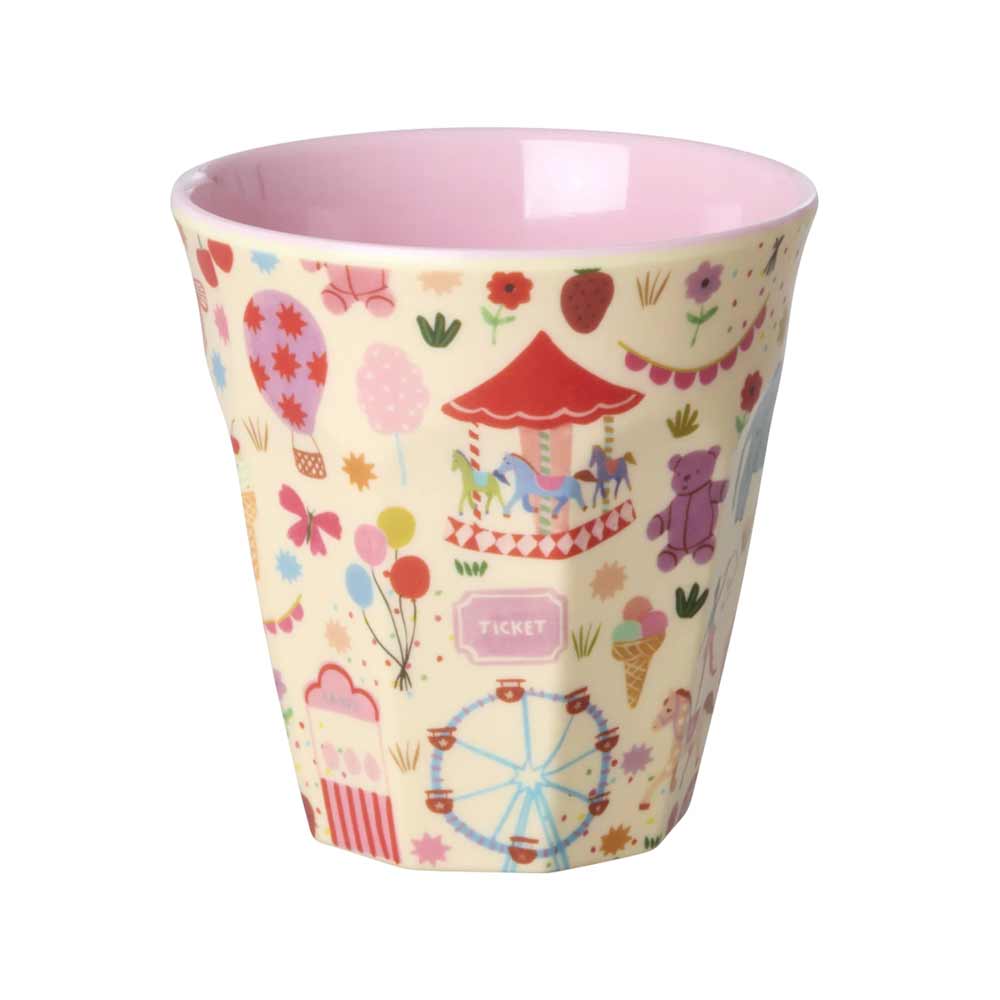 Der Rice Melaminbecher „Fun Fair Medium“ ist in Pastellfarben gehalten, hat eine rosa Innenseite und verspielte Illustrationen von Jahrmarktsymbolen wie einem Karussell, einem Riesenrad, einem Heißluftballon und Eintrittskarten.