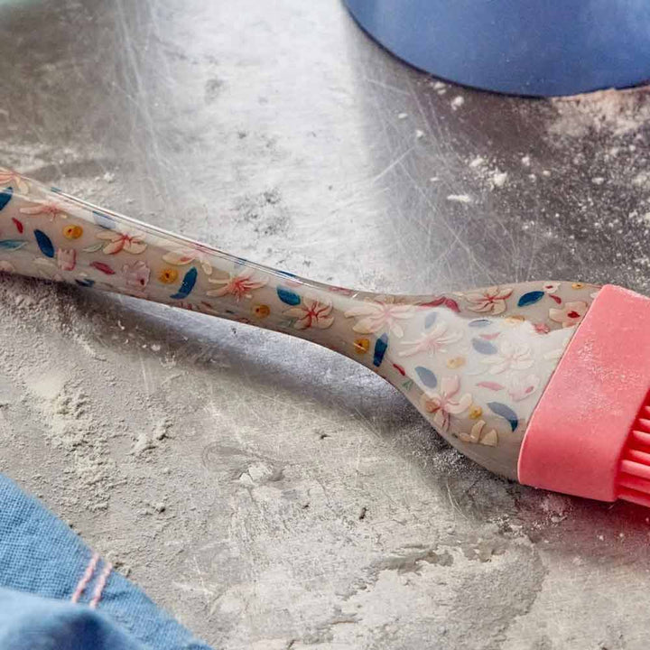 Ein Rice – Silikonpinsel Sandy Flowers liegt auf einer mit Mehl bestäubten Arbeitsplatte.