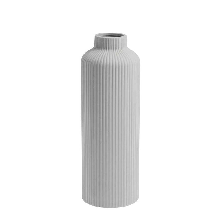 Die Storefactory Ådala Vase Keramik ist eine hohe, zylindrische weiße Vase mit schmalem Hals und vertikaler Rippenstruktur, die aufrecht vor einem schlichten Hintergrund präsentiert wird.