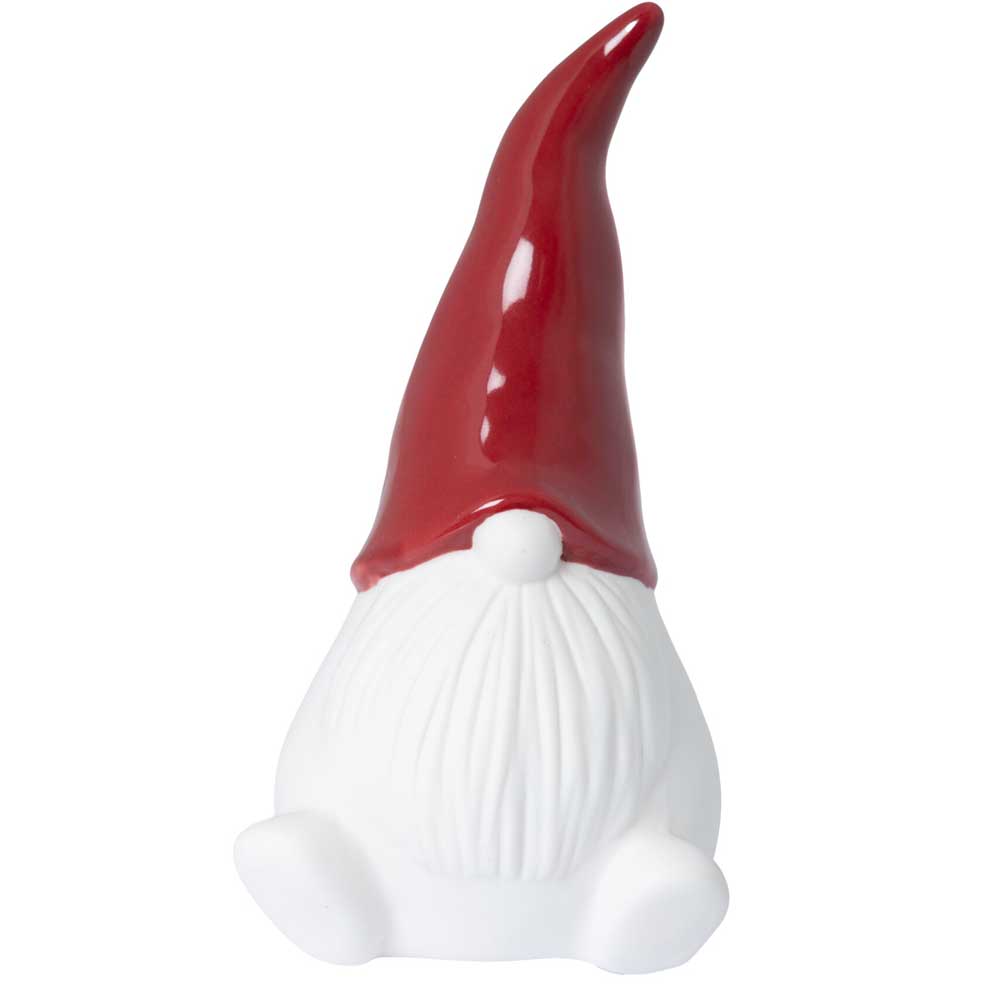 Die Keramikfigur von Storefactory stellt einen Gnom mit Weihnachtsmütze, weißem Bart und verborgenem Gesicht in sitzender Position mit nach vorne ausgestreckten Füßen dar.