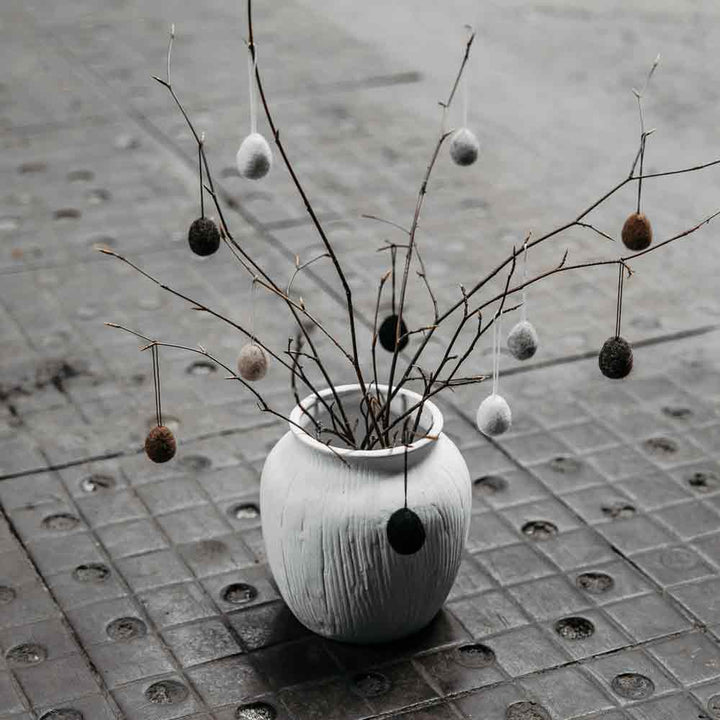 Eine Storefactory – Ullas Ei Anhänger gefüllt mit Osterkugeln auf einem Betonboden.