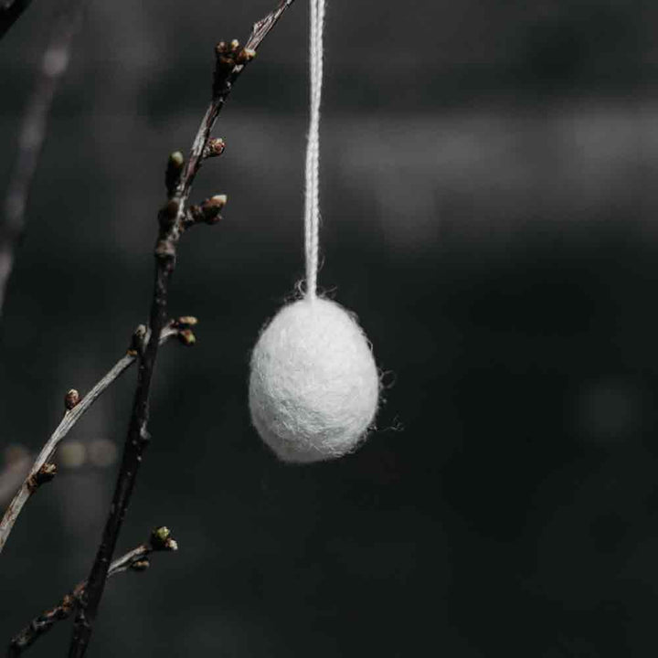 Ein Ullas Ei-Anhänger, der an einem Ast hängt.
