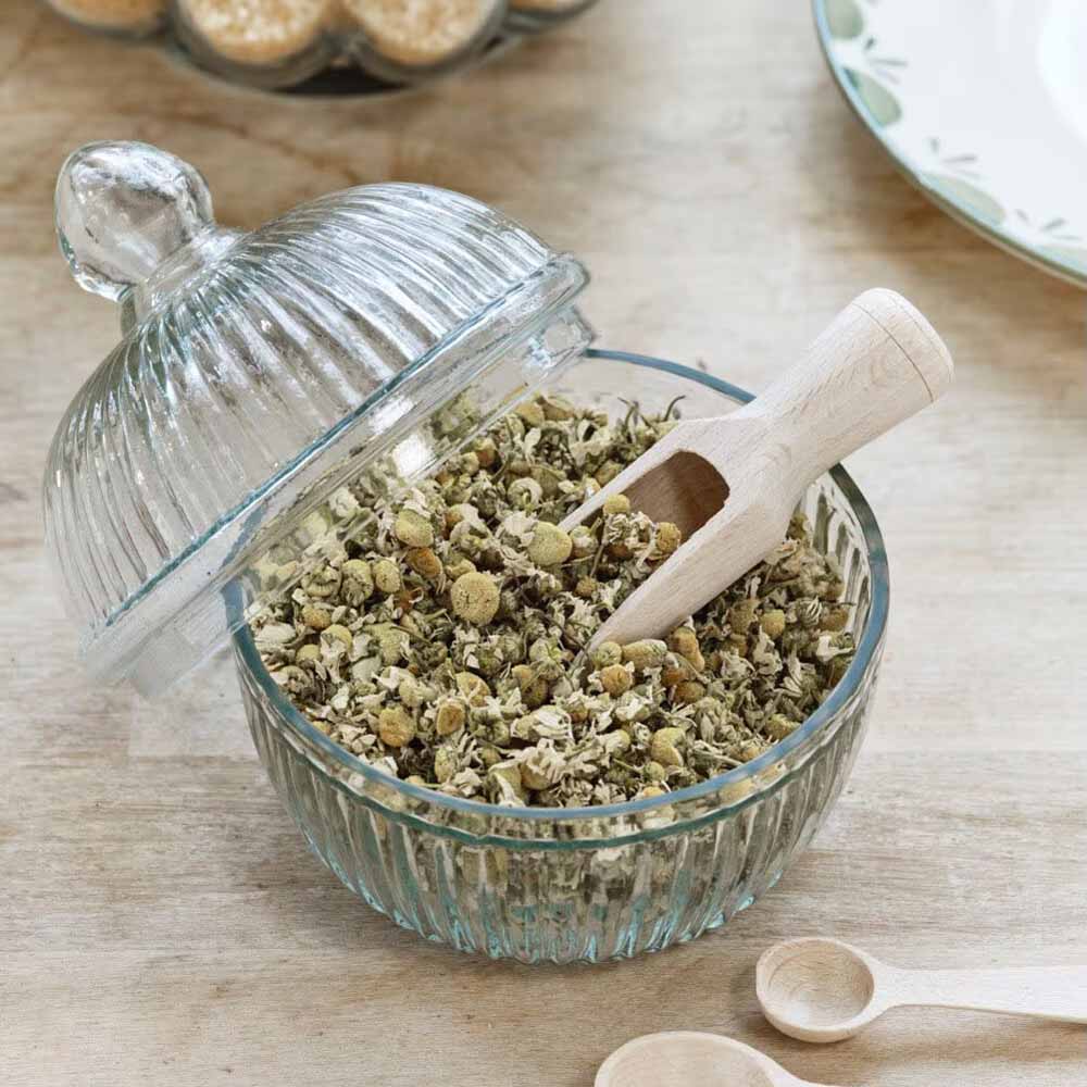 Eine Glasschüssel mit Strömshaga - Holzschaufel Gewürze und Löffeln auf einem Tisch.
