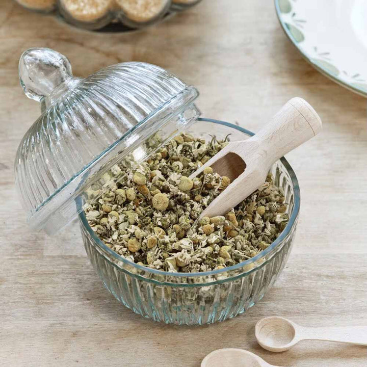 Eine Glasschüssel mit Strömshaga - Holzschaufel Gewürze und Löffeln auf einem Tisch.