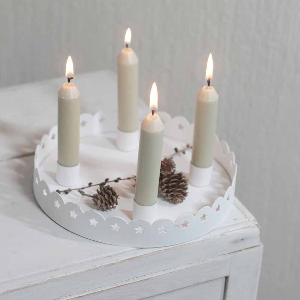 Die VL Home - Kranzschale Shabby Chic mit Sternen für vier Stabkerzen ist mit Tannenzapfen geschmückt und auf einer weißen Holzoberfläche platziert.