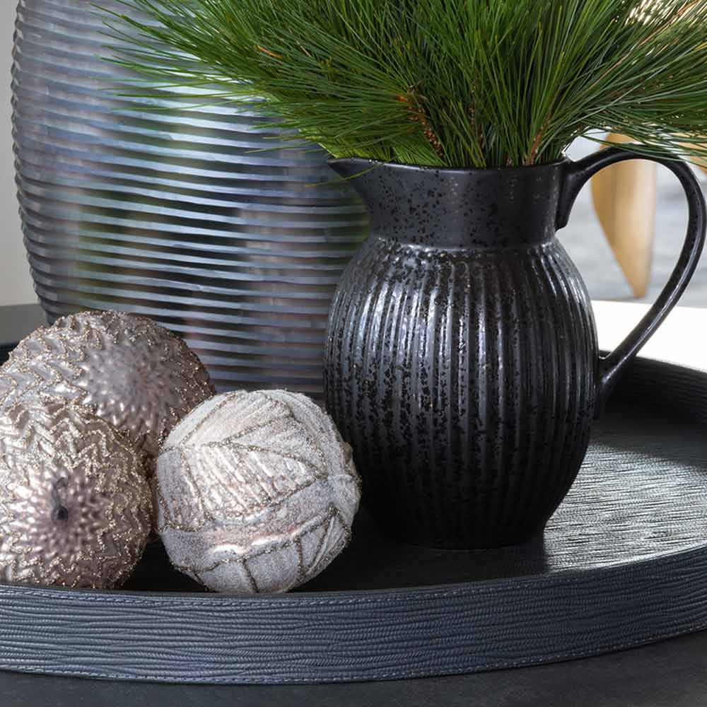 Dekorative Vase mit Tannenzweigen, begleitet von strukturierten Ornamenten auf einem GreenGate - Alice Eierbecher-Tablett.