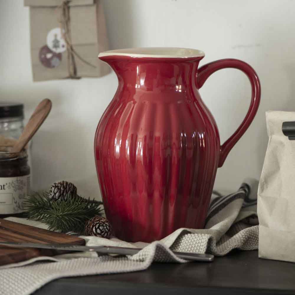 Ein Ib Laursen - Krug Mynte 1,7 Liter auf einer Küchentheke mit Küchenutensilien, Tannenzapfen und verschiedenen Vorratsartikeln im Hintergrund.
