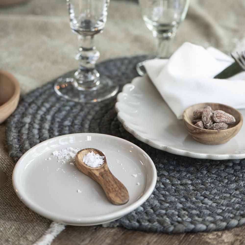 Ein gedeckter Tisch mit Ib Laursen - Frühstücksteller Mynte Tellern, Schüsseln und Löffeln.