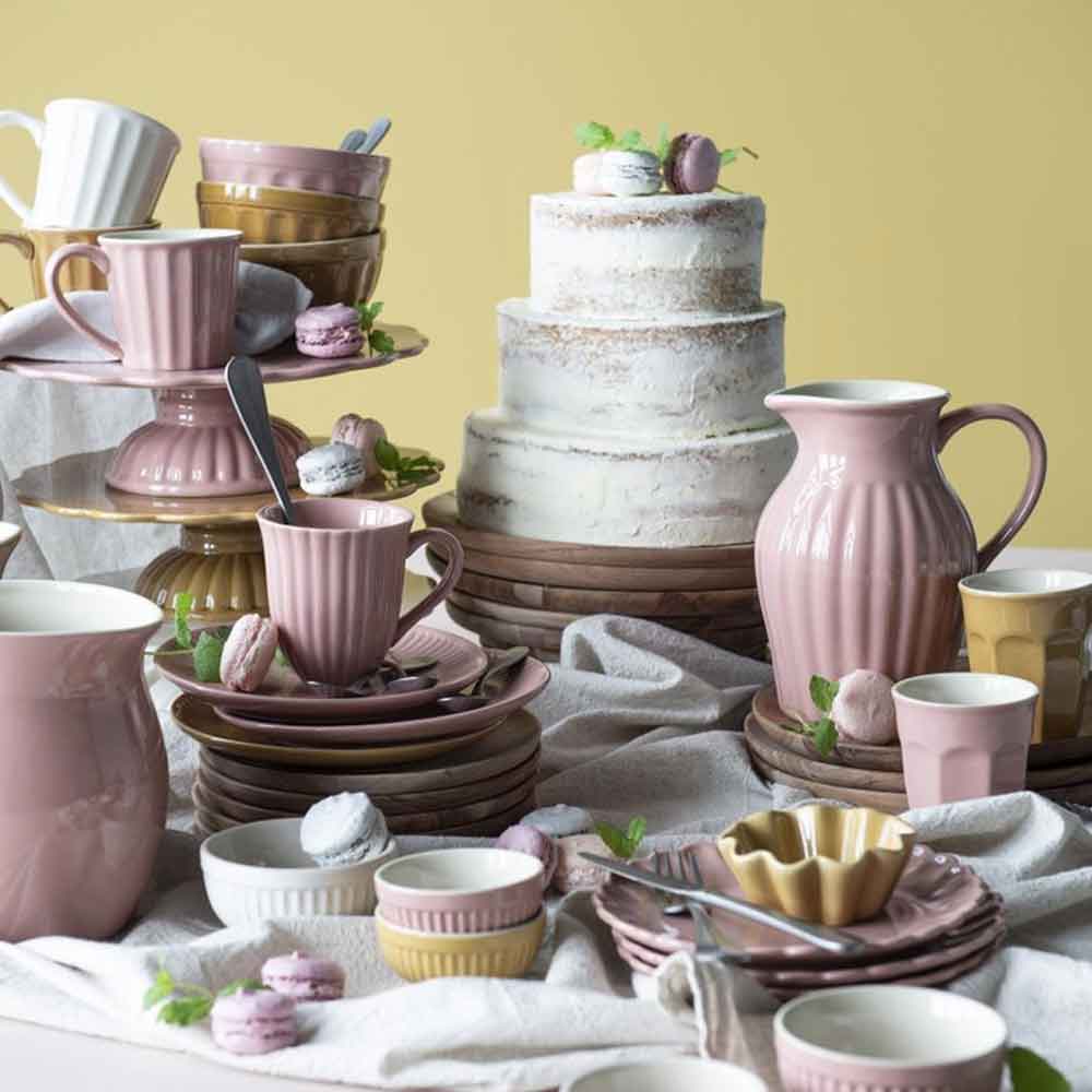 Elegante Tischdekoration mit einem Tortenplatte Mynte von Ib Laursen und einer Kollektion pastellrosa Keramikgeschirr.