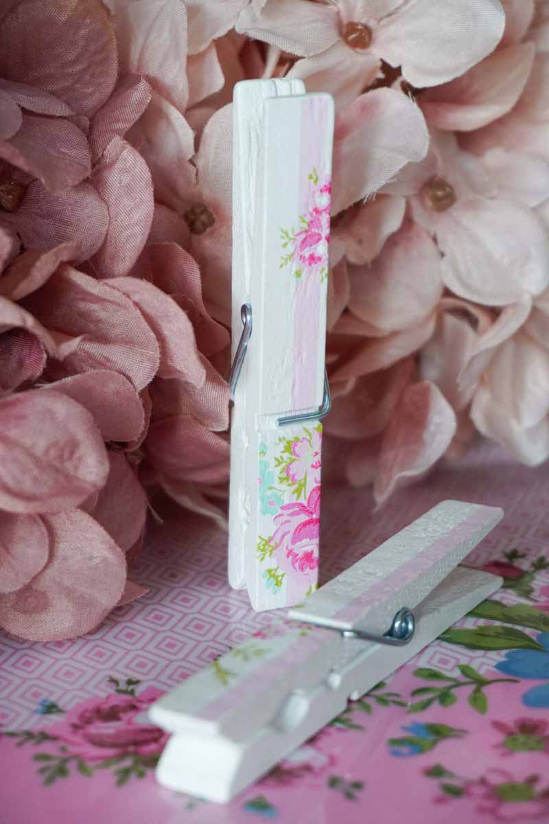 Ein Isabelle Rose - Wäscheklammern Holz 12er-Set neben Blumen.