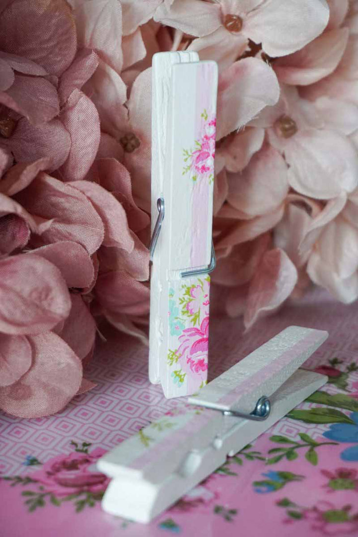 Ein Isabelle Rose - Wäscheklammern Holz 12er-Set neben Blumen.