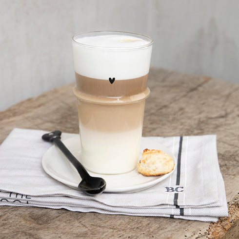 A Bastion Collections - Löffel für Latte Macchiato Herz schwarz auf einem Holztisch.