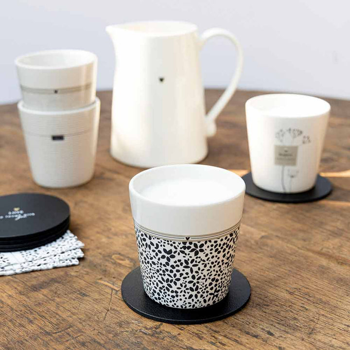 Eine Reihe von Bastion Collections – Becher Wild Flower Tassen und Untersetzer auf einem Holztisch.
