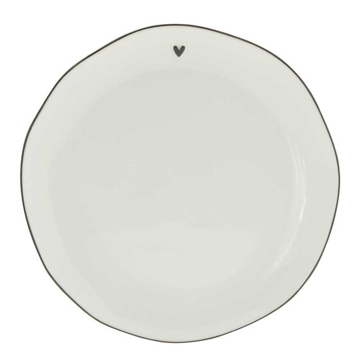 Ein weißes Bastion Collections – Dessertteller Herz mit einem Herz darauf.