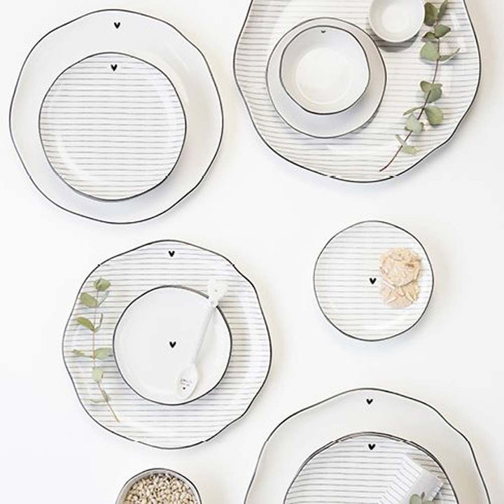 Ein Set der Bastion Collections – Dessertteller Herz mit Streifen mit schwarz-weißem Streifenmuster.