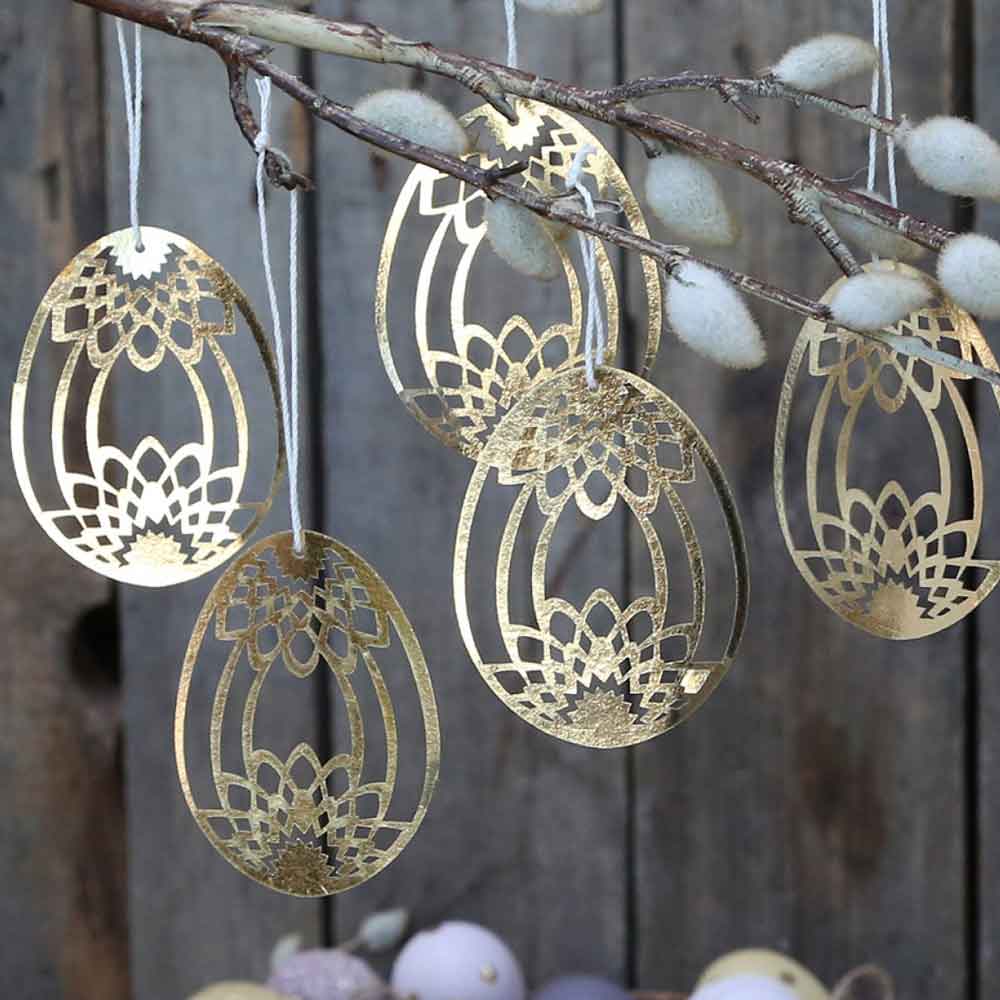 Chic Antique - Osterei Scherenschnitt Gold 5er-Set, lasergeschnittene Ostereierdekorationen, die an einem Ast hängen.