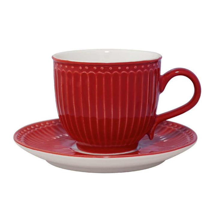 Eine rote GreenGate - Alice Teetasse aus Keramik mit passender Untertasse, mit geripptem Design auf weißem Hintergrund.