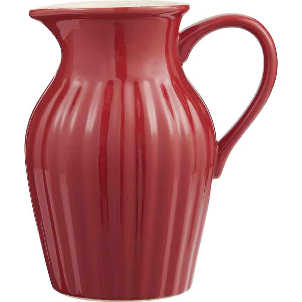 Ein glänzend roter Ib Laursen - Krug Mynte 1,7 Liter Krug mit geschwungenem Henkel und senkrechten Rillen, isoliert auf weißem Hintergrund.