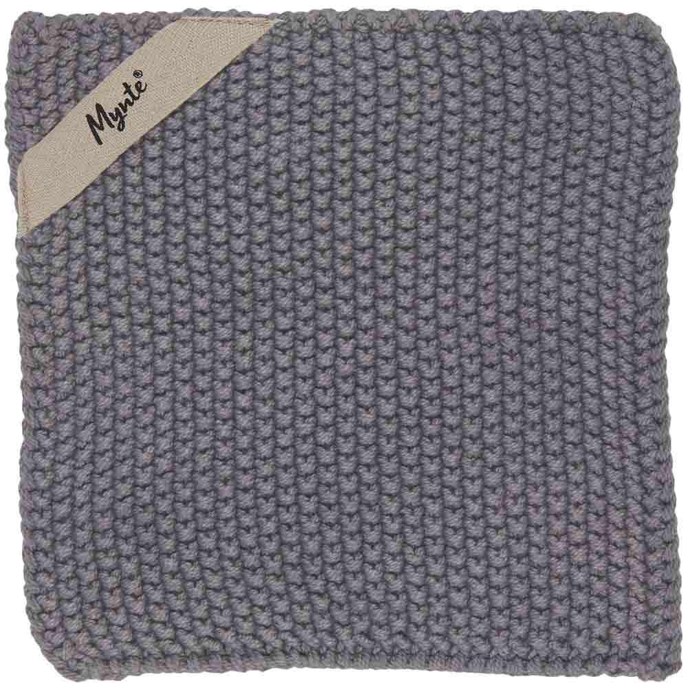 Ein quadratisches, handgestricktes, graues Geschirrtuch mit einem kleinen beigen Etikett mit der Aufschrift „Ib Laursen – Topflappen Mynte“ in der oberen linken Ecke.
