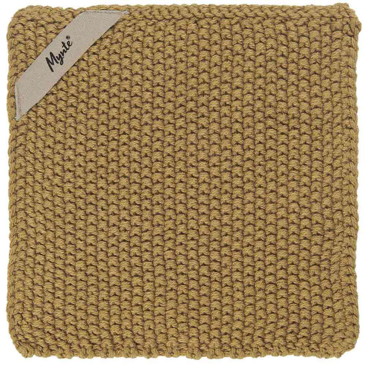 Ein quadratischer, gestrickter Topflappen in einem soliden Hellbraun mit einem kleinen Etikett mit der Aufschrift „Ib Laursen – Topflappen Mynte“, das an der Ecke aufgenäht ist.