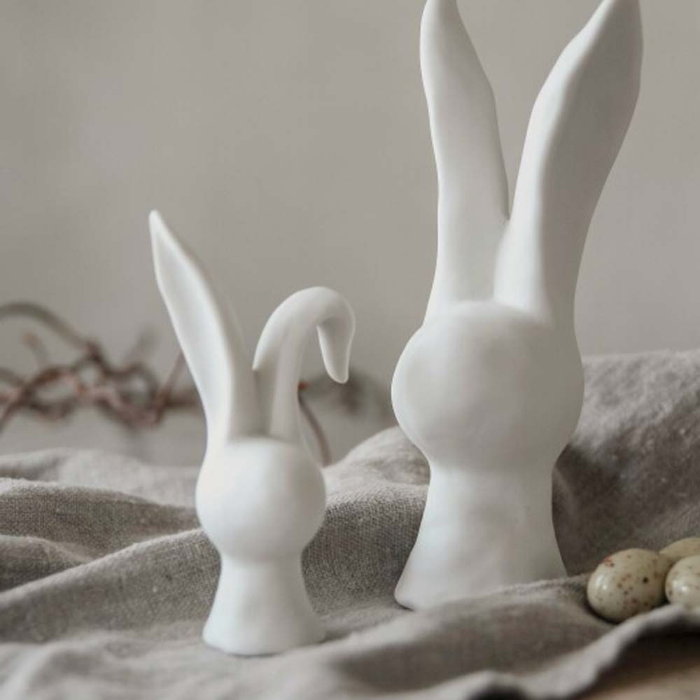 Two Majas Cottage – Hase kleine Hasenfiguren auf einer strukturierten Stoffoberfläche.
