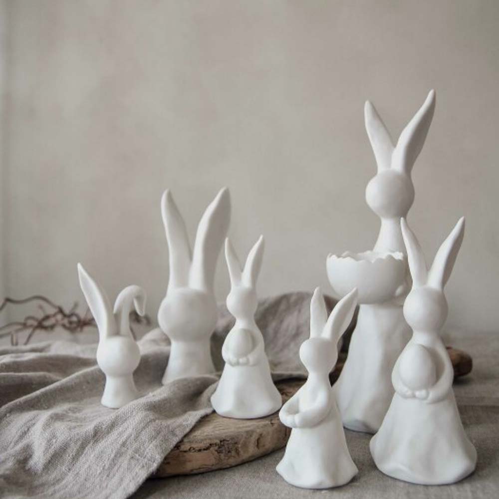 Eine Sammlung kleiner Hasenfiguren von Majas Cottage – Hase auf einem weichen, neutralen Hintergrund.