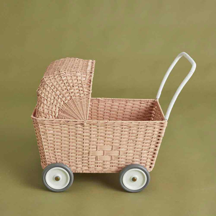 Olli Ella - Puppenwagen Strolley rosa auf Rädern vor schlichtem beigem Hintergrund.