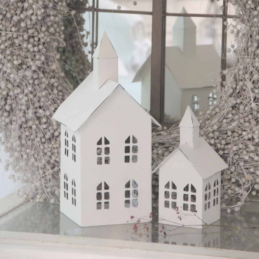 Ein VL Home - Metallhaus Kirche weiß groß auf einer Fensterbank.